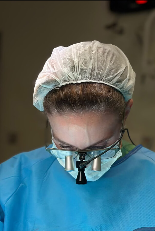 Dra. Christiana Vanni durante a cirurgia: a concentração e o rigor técnico exigidos na anastomose dos vasos do retalho de fíbula são visíveis neste registro intraoperatório